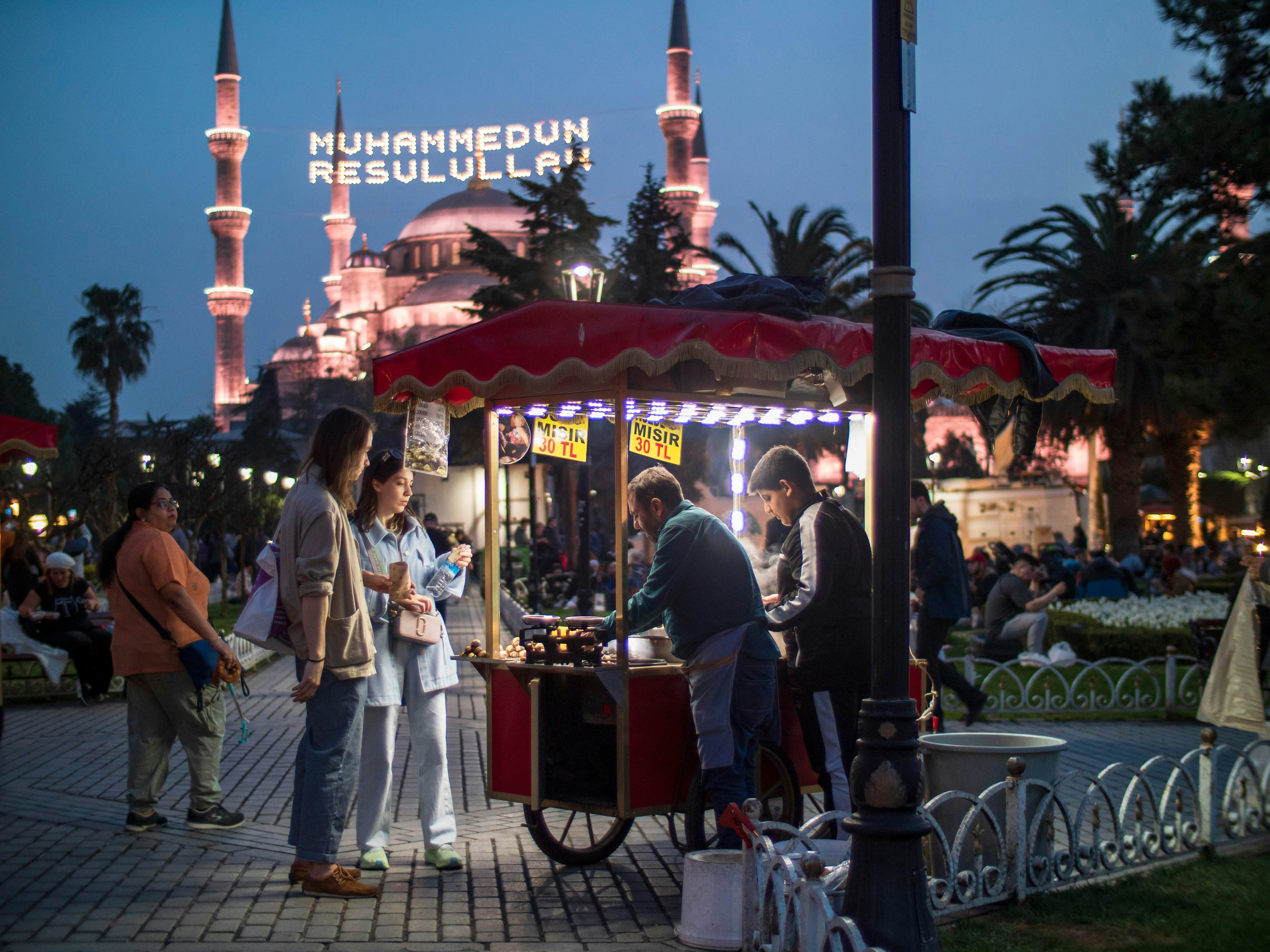 People walking around Sultanahmet Square after iftar during Ramadan, the milk corn seller and the Sultanahmet Mosque behind, or Blue Mosque. Türkiye istanbul fatih March 27, 2024, License Type: media, Download Time: 2024-07-29T17:39:48.000Z, User: nic.dhoedt_lonelyplanet, Editorial: true, purchase_order: 56530, job: Global Publishing WIP, client: Lonely PlanetMiddle East 10, other: Nicolas D'Hoedt