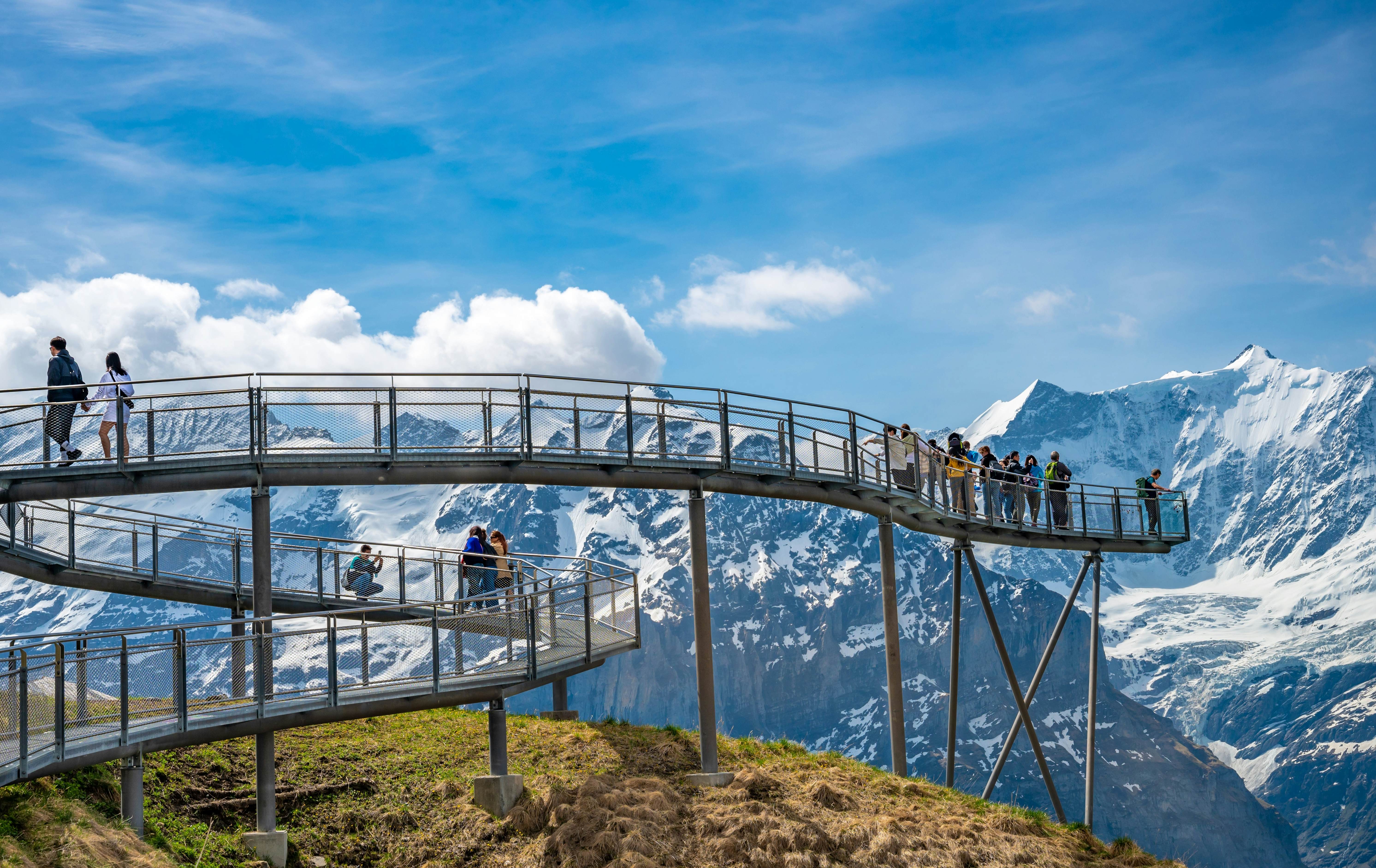 GRINDELWALD, SWITZERLAND - MAY 17, 2022 : View of sky cliff walk metal bridge at First peak above Grindelwald village. Jungfrau region, Switzerland. License Type: media Download Time: 2024-02-21T15:18:09.000Z User: Is Editorial: Yes purchase_order: 