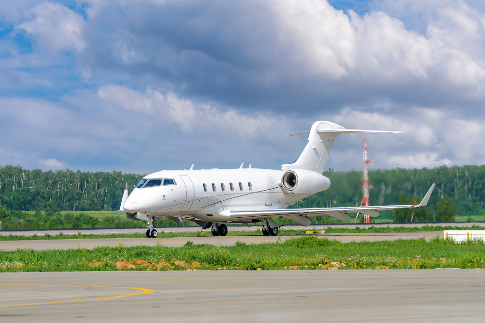 A private white business jet on the runway is preparing for takeoff.